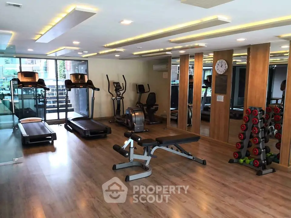 Modern gym with state-of-the-art equipment and mirrored walls in a luxury residential building.