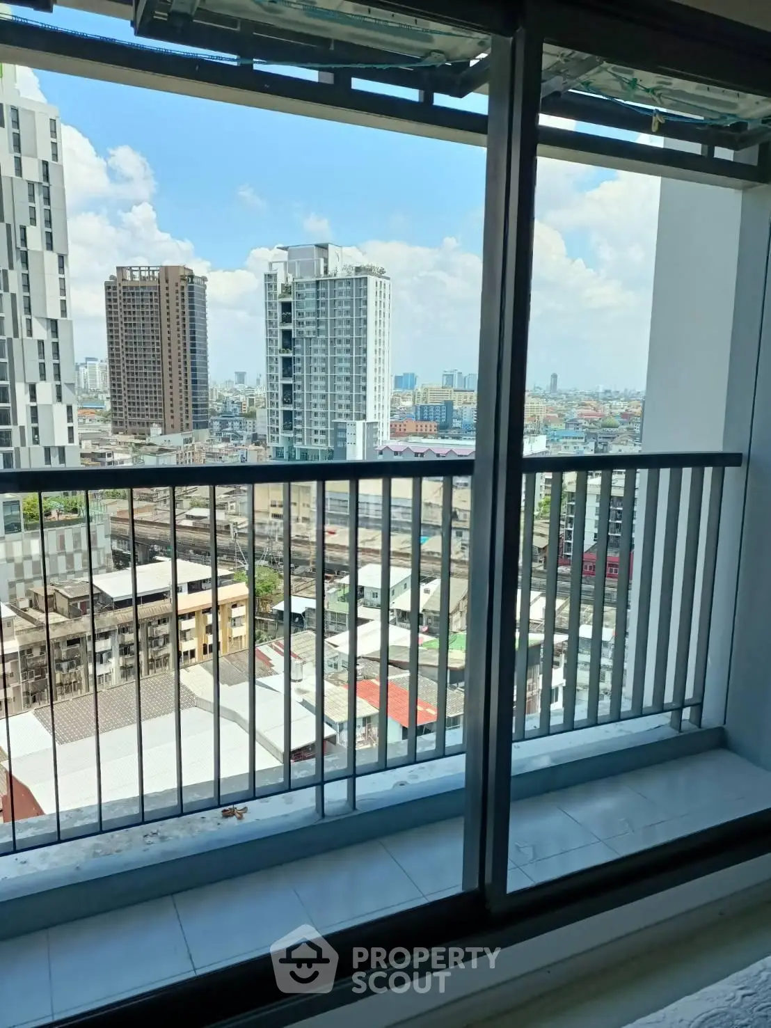 Stunning cityscape view from a high-rise balcony with modern railing.