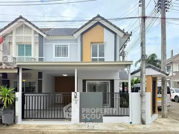 Modern two-story townhouse with sleek design and gated entrance in suburban neighborhood.