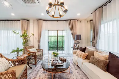Elegant living room with chic decor, large windows, and cozy seating area, perfect for relaxation and entertaining.