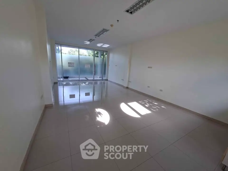 Spacious empty room with large windows and tiled flooring, ideal for customization.