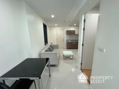 Sleek modern studio apartment with gleaming white tiles, featuring a cozy living area, compact kitchen with wooden cabinets, and a well-lit ambiance perfect for urban living.