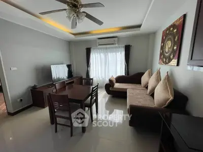 Cozy living room with modern furniture and ceiling fan, perfect for relaxation.