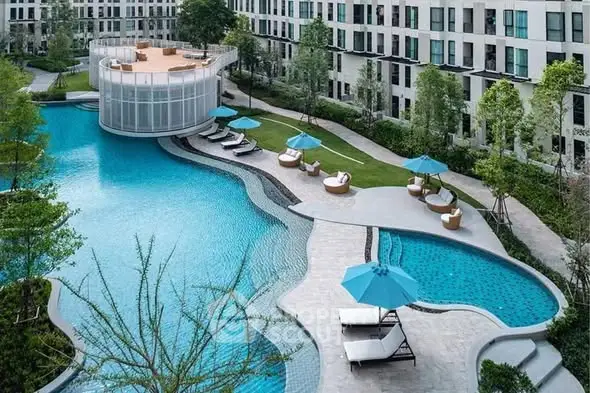 Luxurious modern apartment complex with stunning pool and lush greenery.