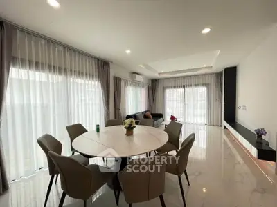 Spacious modern living room with elegant dining area and large windows.