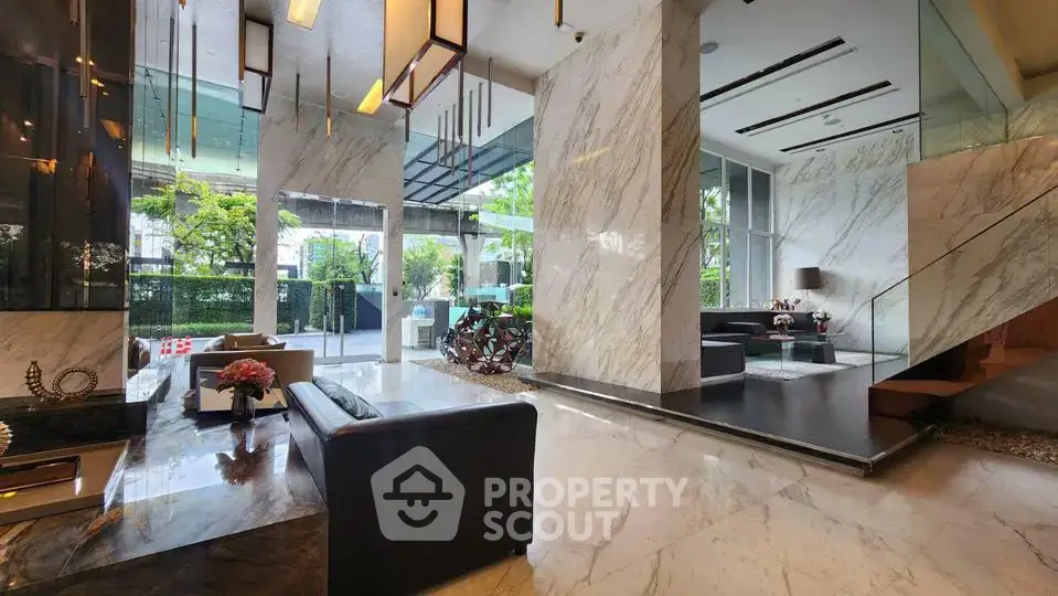 Luxurious modern lobby with marble floors and elegant seating area in upscale building.