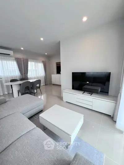 Modern living room with sleek furniture and large TV, perfect for relaxation.