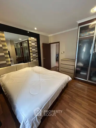 Spacious bedroom with modern decor and ample storage in a stylish apartment.