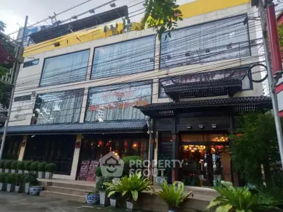 Charming commercial building with traditional facade and lush greenery in urban setting.