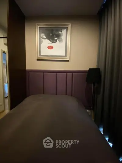 Cozy bedroom with elegant decor and modern artwork, featuring plush bedding and ambient lighting.