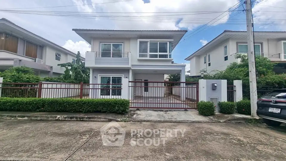 Modern two-story house with spacious driveway and lush greenery in a serene neighborhood.
