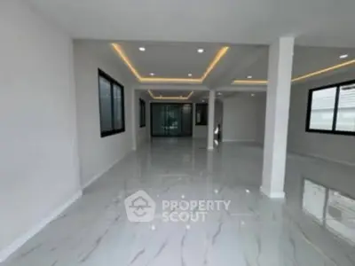 Spacious modern interior with sleek marble flooring and recessed lighting, perfect for versatile living spaces.