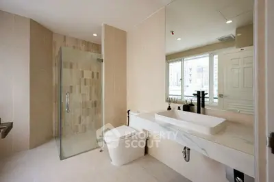 Spacious modern bathroom with glass shower and large mirror