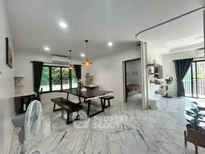 Spacious open-plan living and dining area with modern marble flooring and natural light.