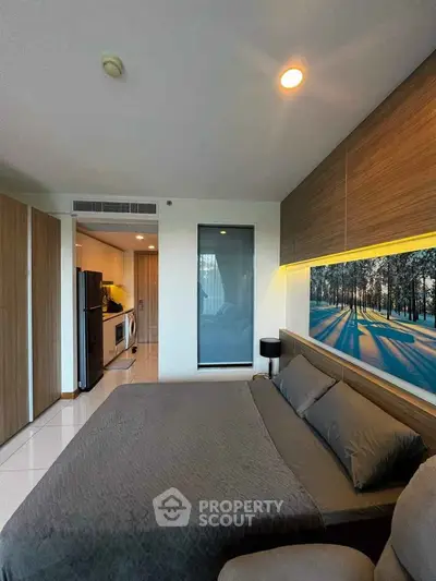 Modern bedroom with stylish decor and open kitchen layout in a cozy apartment.