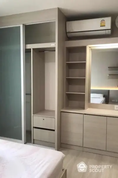 Modern bedroom with built-in wardrobe and air conditioning unit