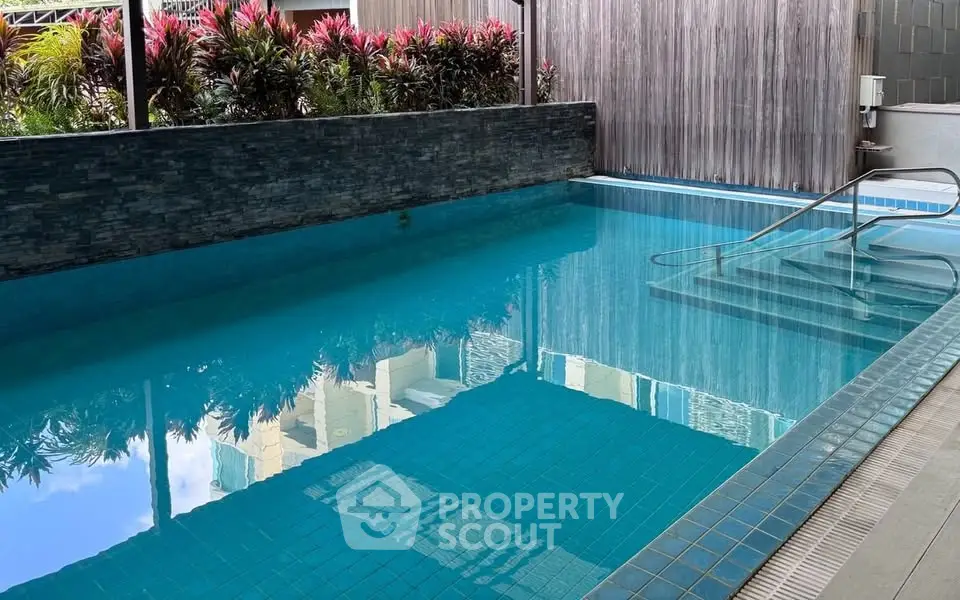 Luxurious residential pool with modern design and lush greenery, perfect for relaxation and leisure.