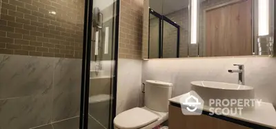 Modern bathroom with sleek design featuring glass shower and elegant fixtures.