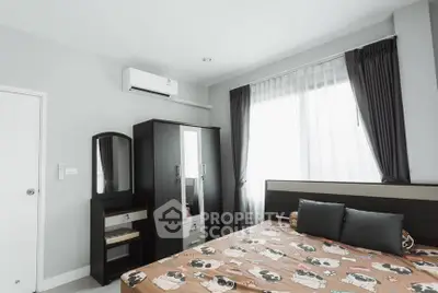 Cozy bedroom with modern furniture and large window for natural light.