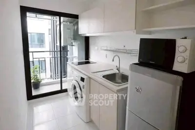 Modern kitchen with sleek appliances and balcony view in urban apartment