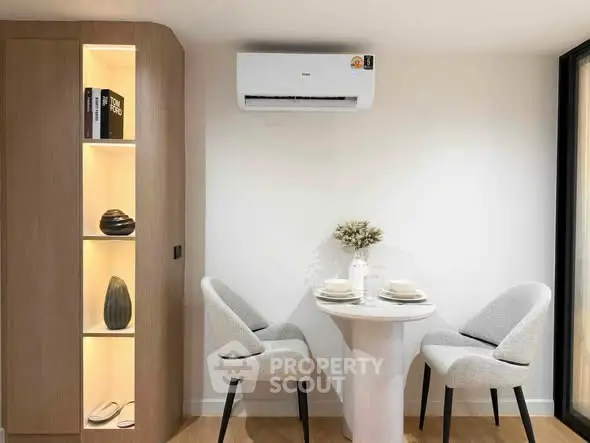 Modern dining nook with elegant chairs and built-in shelving in a cozy apartment.