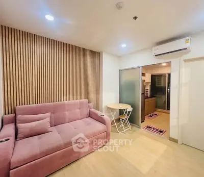 Modern living room with pink sofa and wooden accent wall in cozy apartment