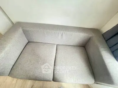Modern gray sofa in a cozy living room setting, perfect for relaxation and comfort.