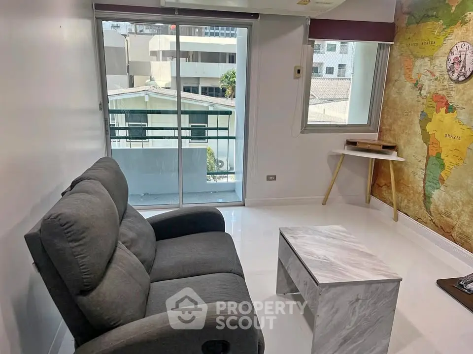 Modern living room with cozy sofa and world map accent wall, featuring a balcony view.