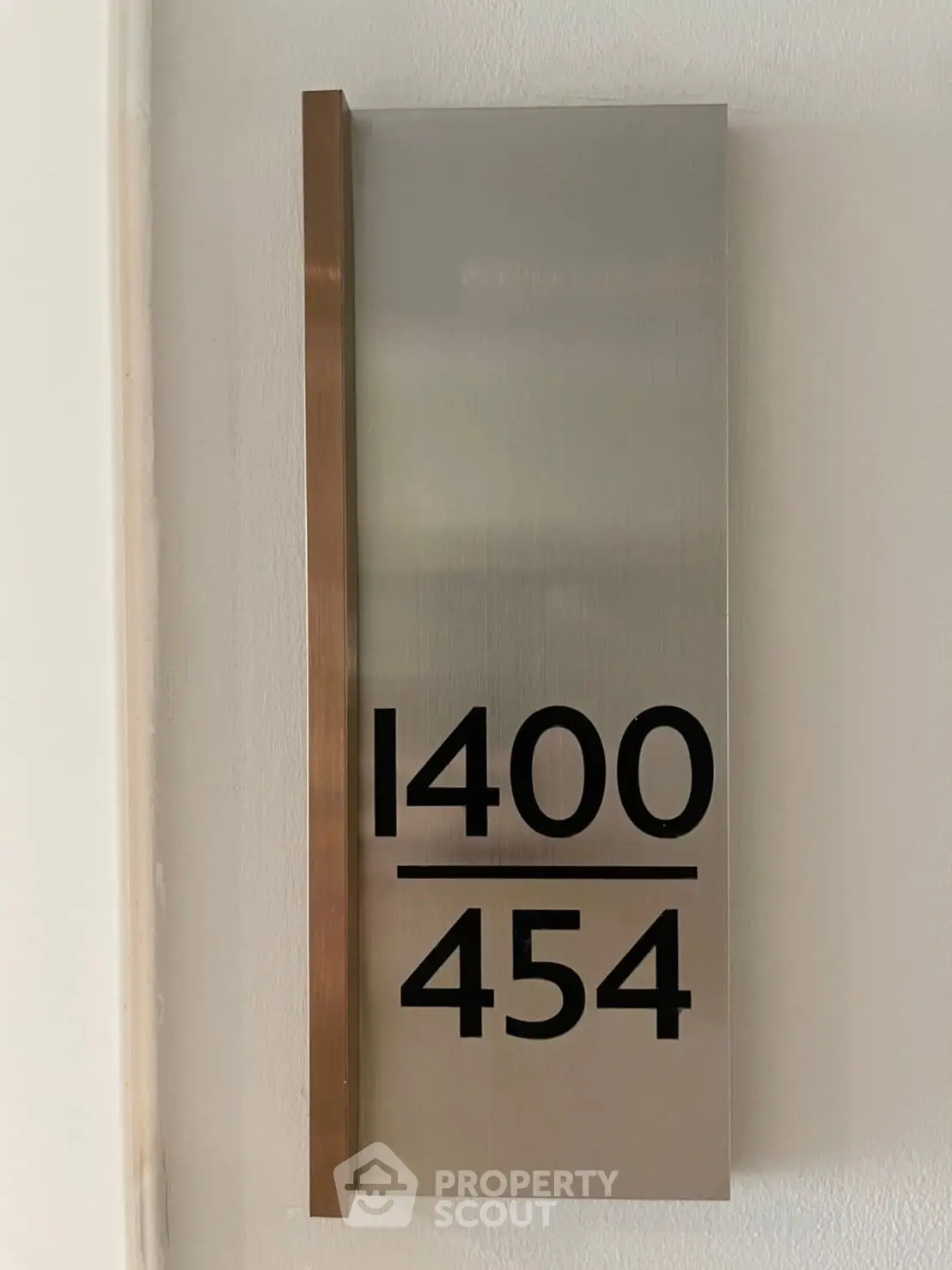 Modern apartment number plaque with sleek design and metallic finish.