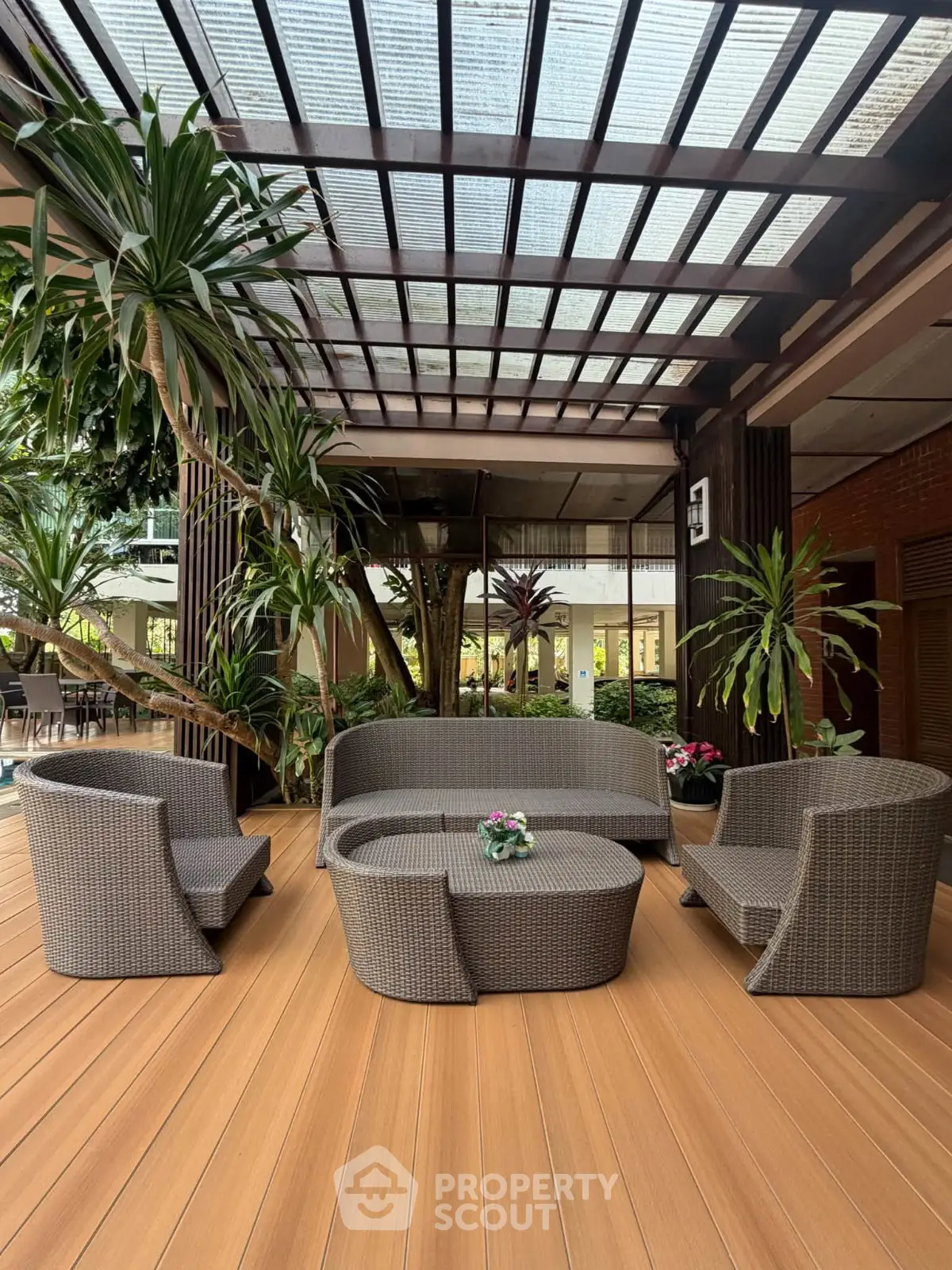 Elegant outdoor seating area with modern wicker furniture and lush greenery, perfect for relaxation and entertaining.
