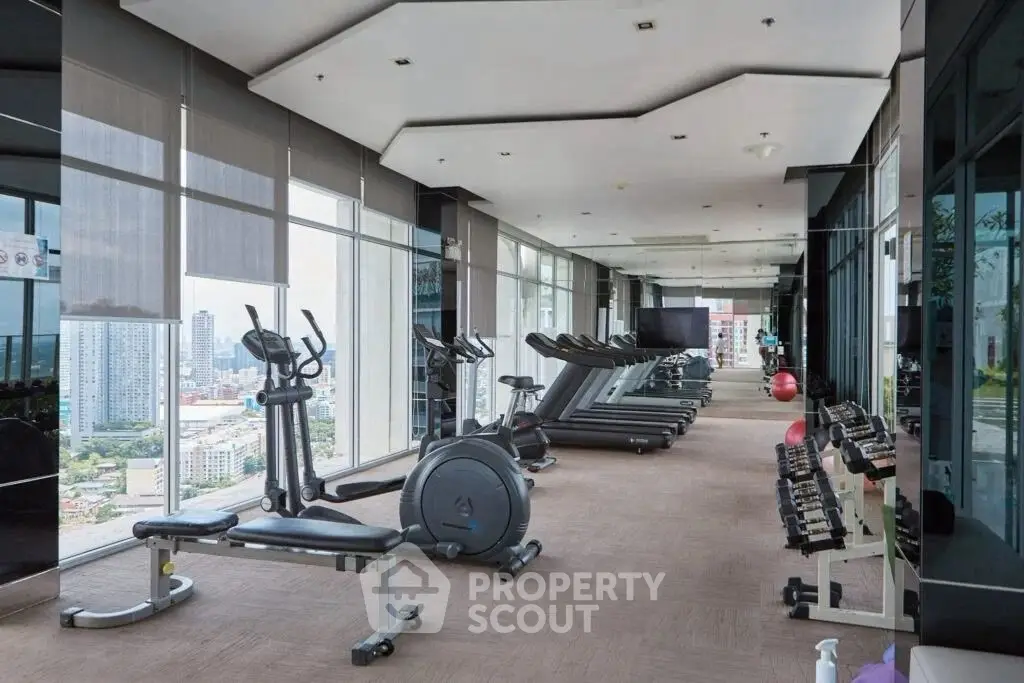 Luxurious high-rise gym with panoramic city views and modern fitness equipment.