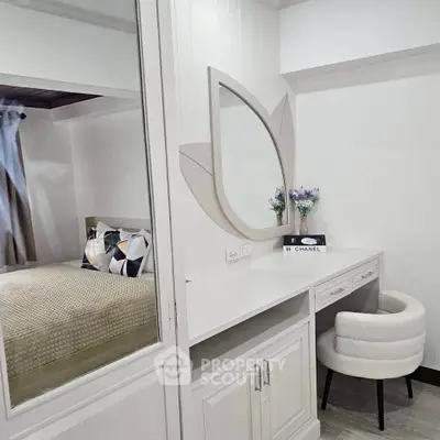Chic bedroom with stylish vanity and cozy chair, perfect for modern living.