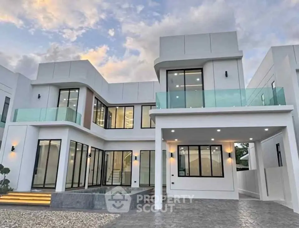 Stunning modern villa with large glass windows and spacious balcony, perfect for luxury living.