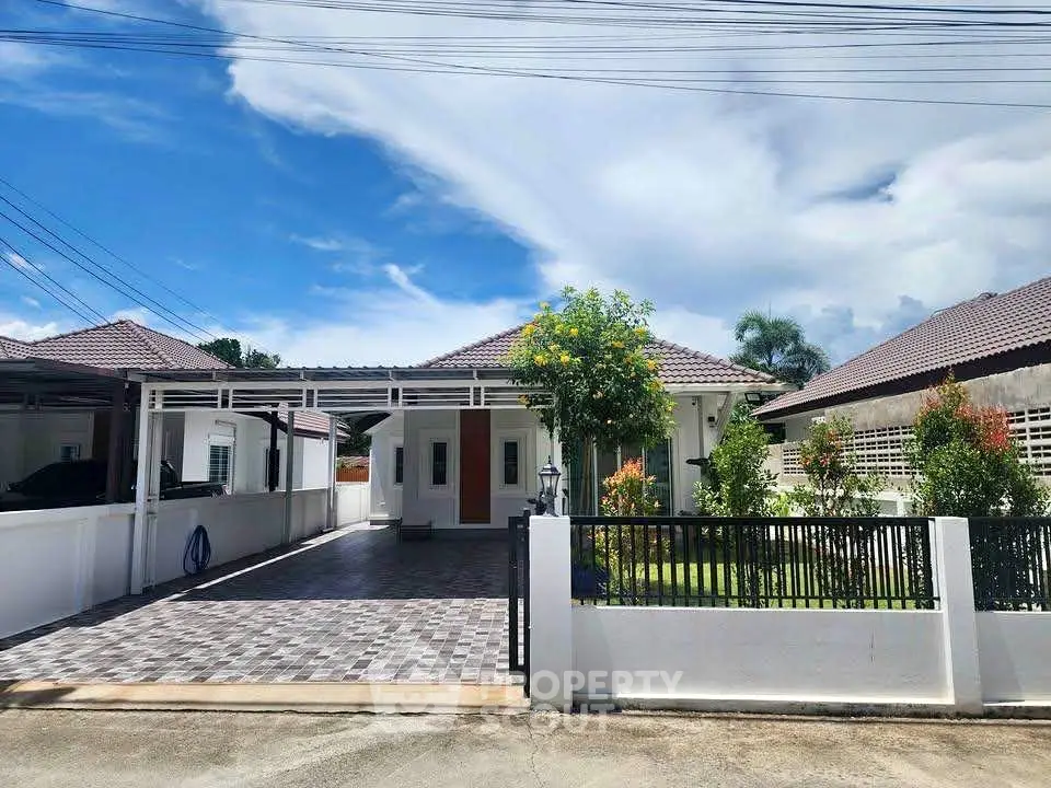 Charming single-story home with spacious driveway and lush garden, perfect for family living.