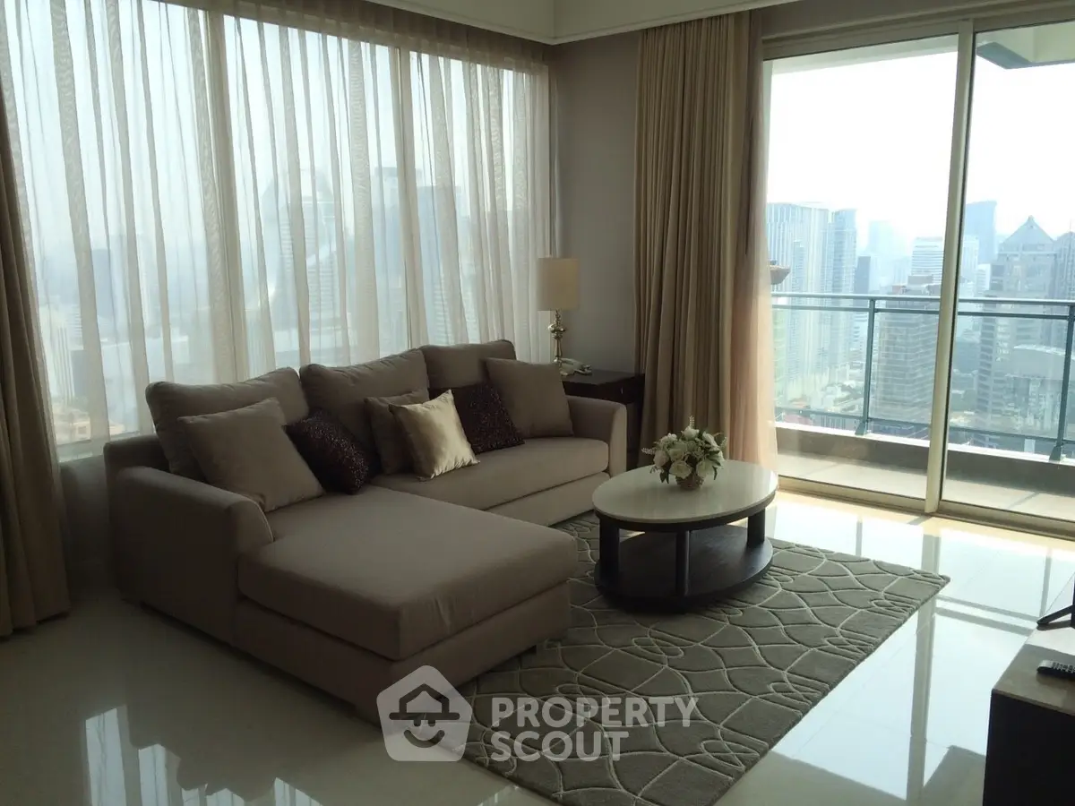 Luxurious living room with city view and elegant decor in high-rise apartment.