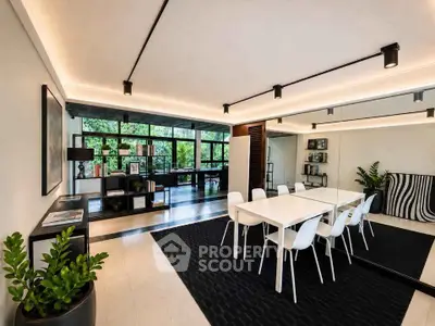 Modern open-plan living and dining area with sleek furniture and large windows.
