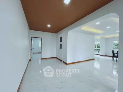 Spacious modern living area with elegant ceiling design and large windows