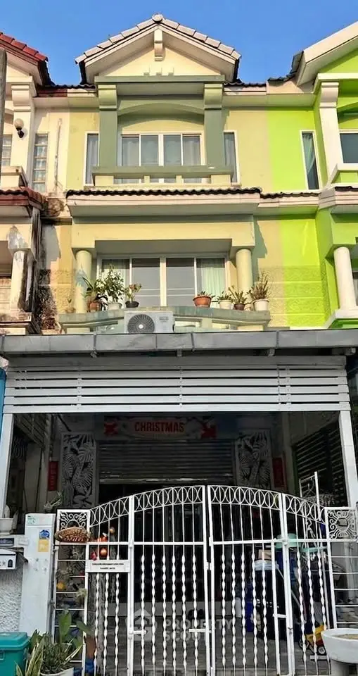 Charming townhouse exterior with colorful facade and gated entrance, perfect for modern urban living.