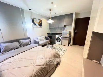 Modern studio apartment with cozy bed, compact kitchen, and stylish decor.