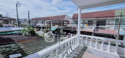 Charming balcony view of suburban neighborhood with tiled roofs and clear blue sky.