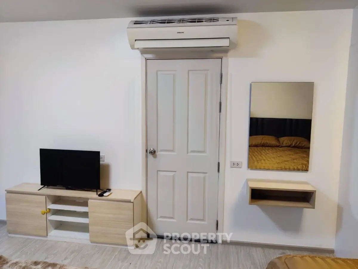 Modern bedroom with air conditioning, TV, and stylish furnishings.