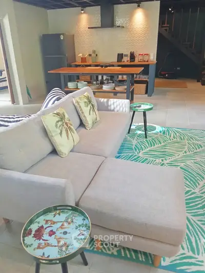 Stylish open-plan living room with modern kitchen and cozy seating area, perfect for entertaining.