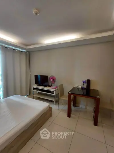 Modern bedroom with minimalist decor, featuring a bed, TV, and small dining area, perfect for urban living.