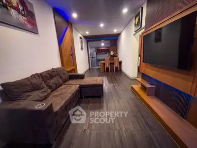 Modern living room with stylish decor and open layout, featuring a cozy sectional sofa and sleek entertainment center.