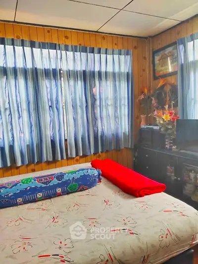 Cozy bedroom with wooden paneling and natural light
