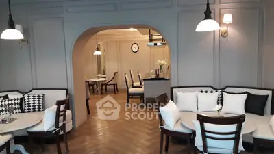 Elegant living room with stylish seating and archway leading to dining area