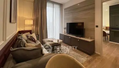Elegant living room with modern decor and large TV, featuring cozy seating and natural light.