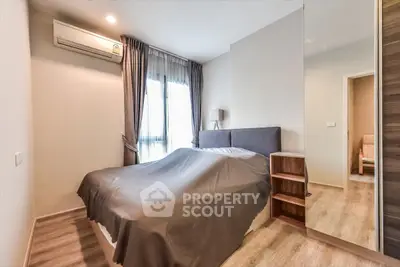 Modern bedroom with cozy decor and natural light in a stylish apartment.