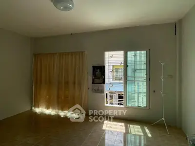 Spacious living room with natural light and tiled flooring