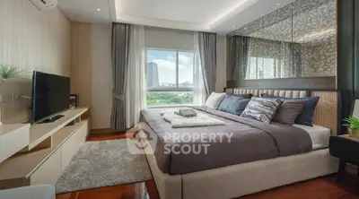 Luxurious modern bedroom with elegant decor and large window view.